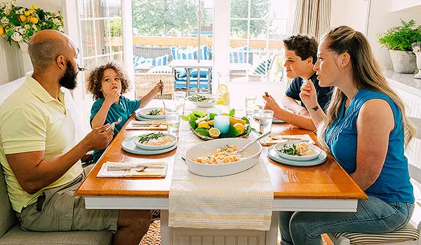 family of four eating dinner at table
